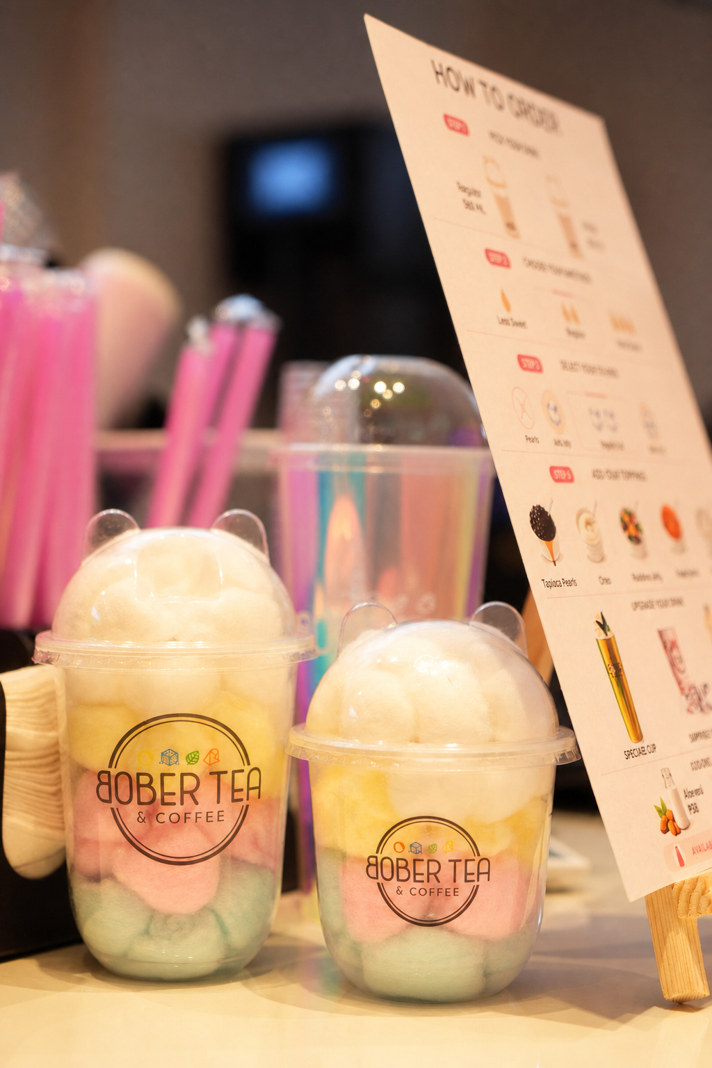 Two Bober Tea cotton candy drinks displayed beside the café menu