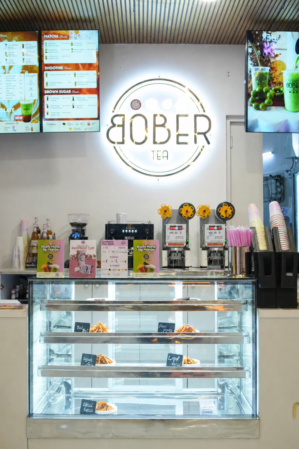 Bober Tea café counter with illuminated brand sign and digital menus