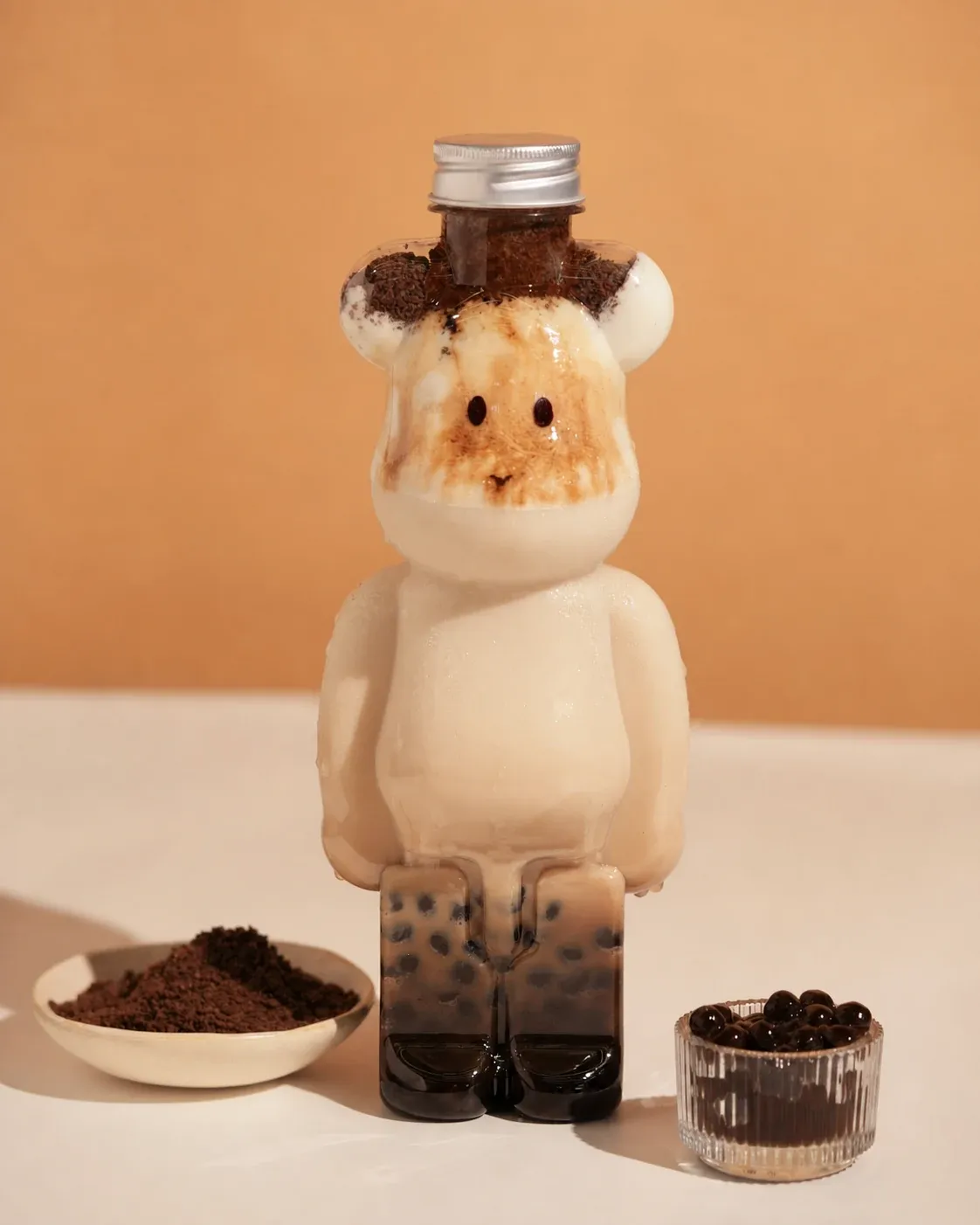 Cream milk tea served in a bear-shaped Bear Brick bottle with boba pearls