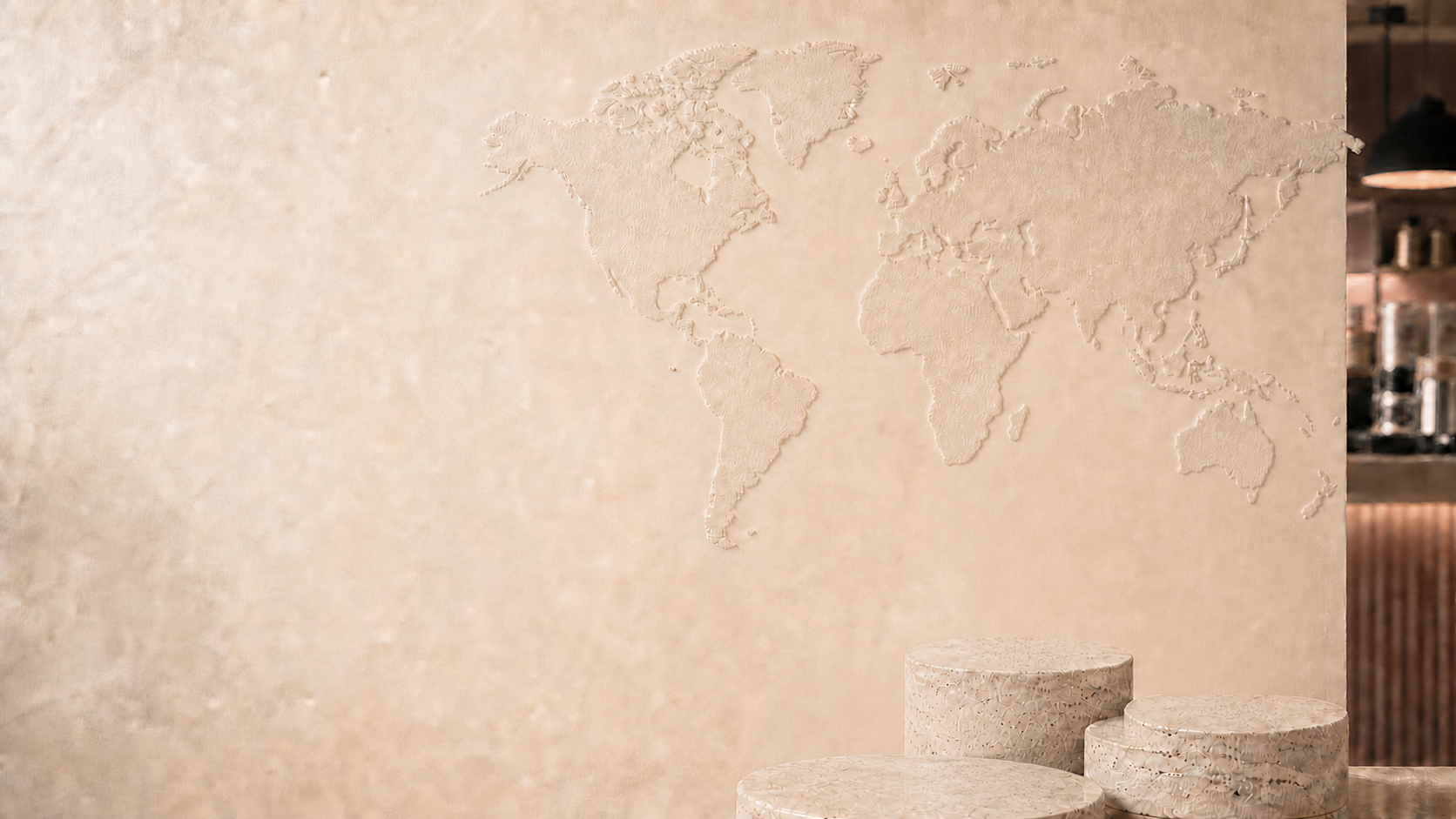 Textured world map wall with stone product pedestals